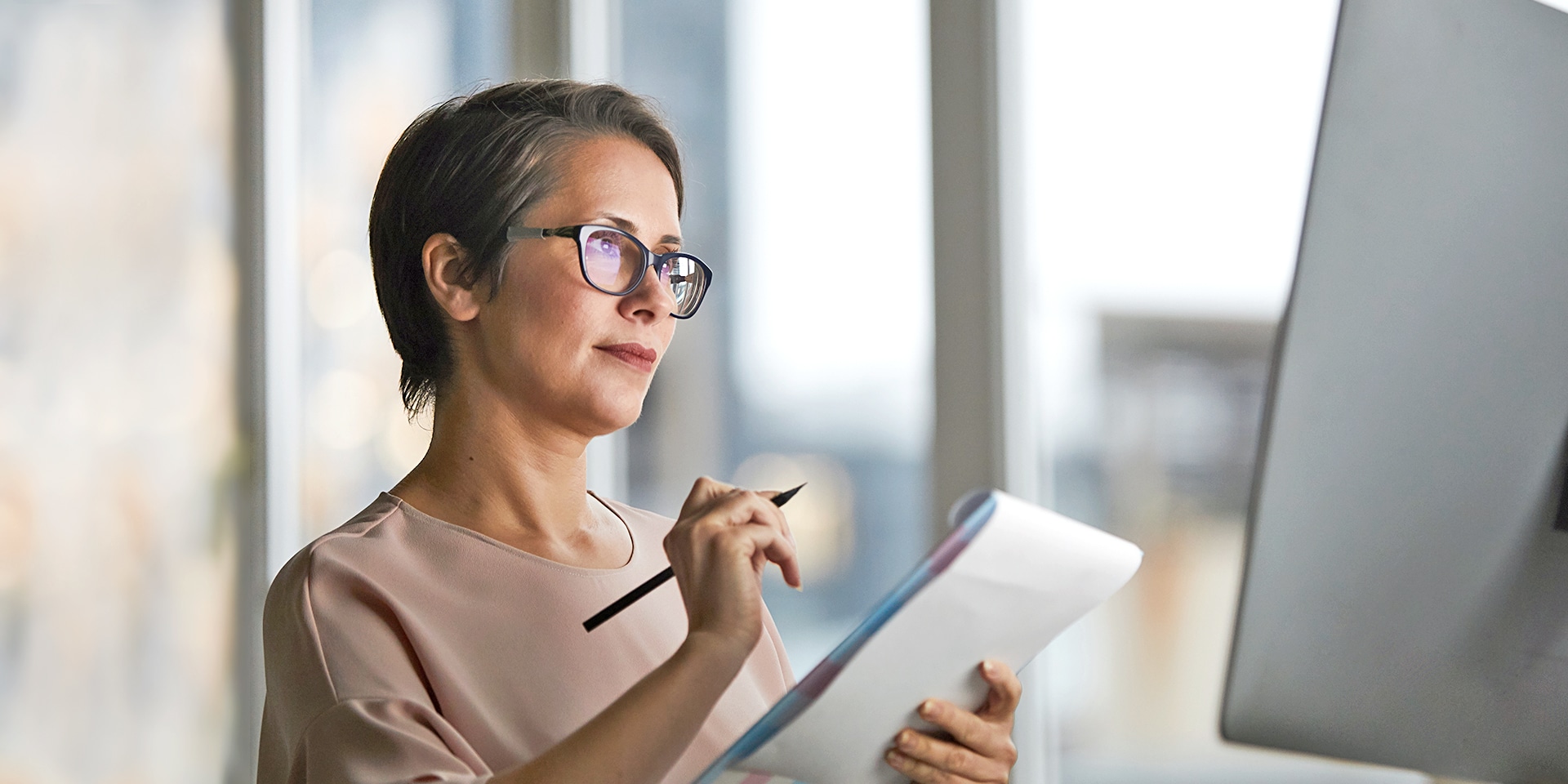 older woman taking notes from computer